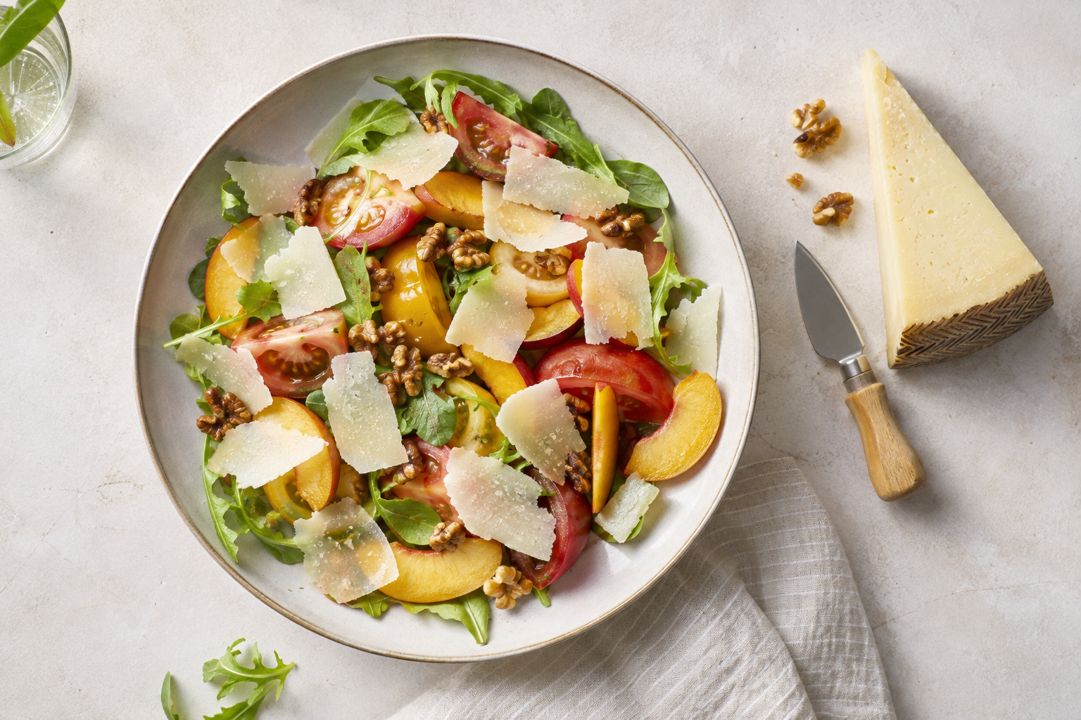 Ensalada de verano con queso español en lascas, tomate, fruta y frutos secos