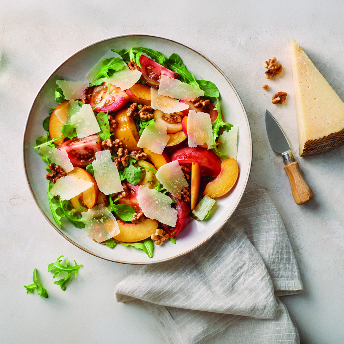 Ensalada de verano con queso español, tomate, fruta y nueces